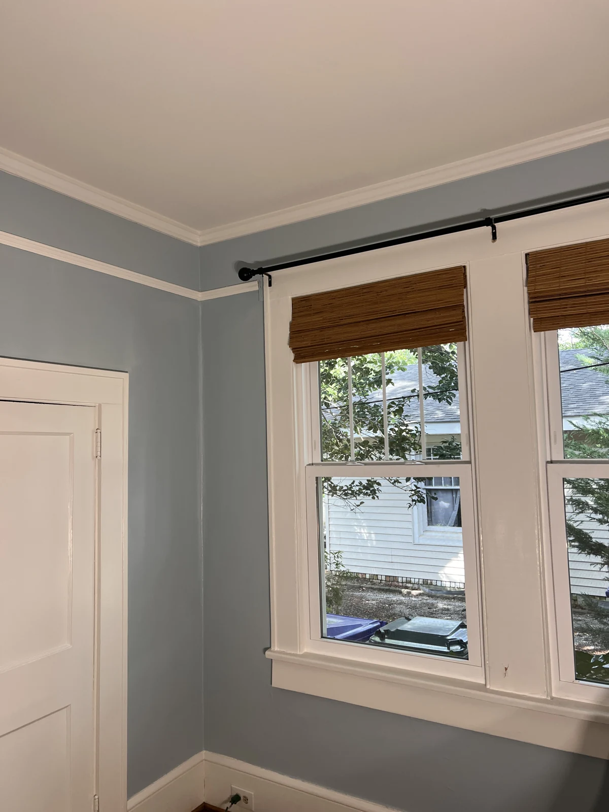 The same room with soft blue walls and white trim after painting