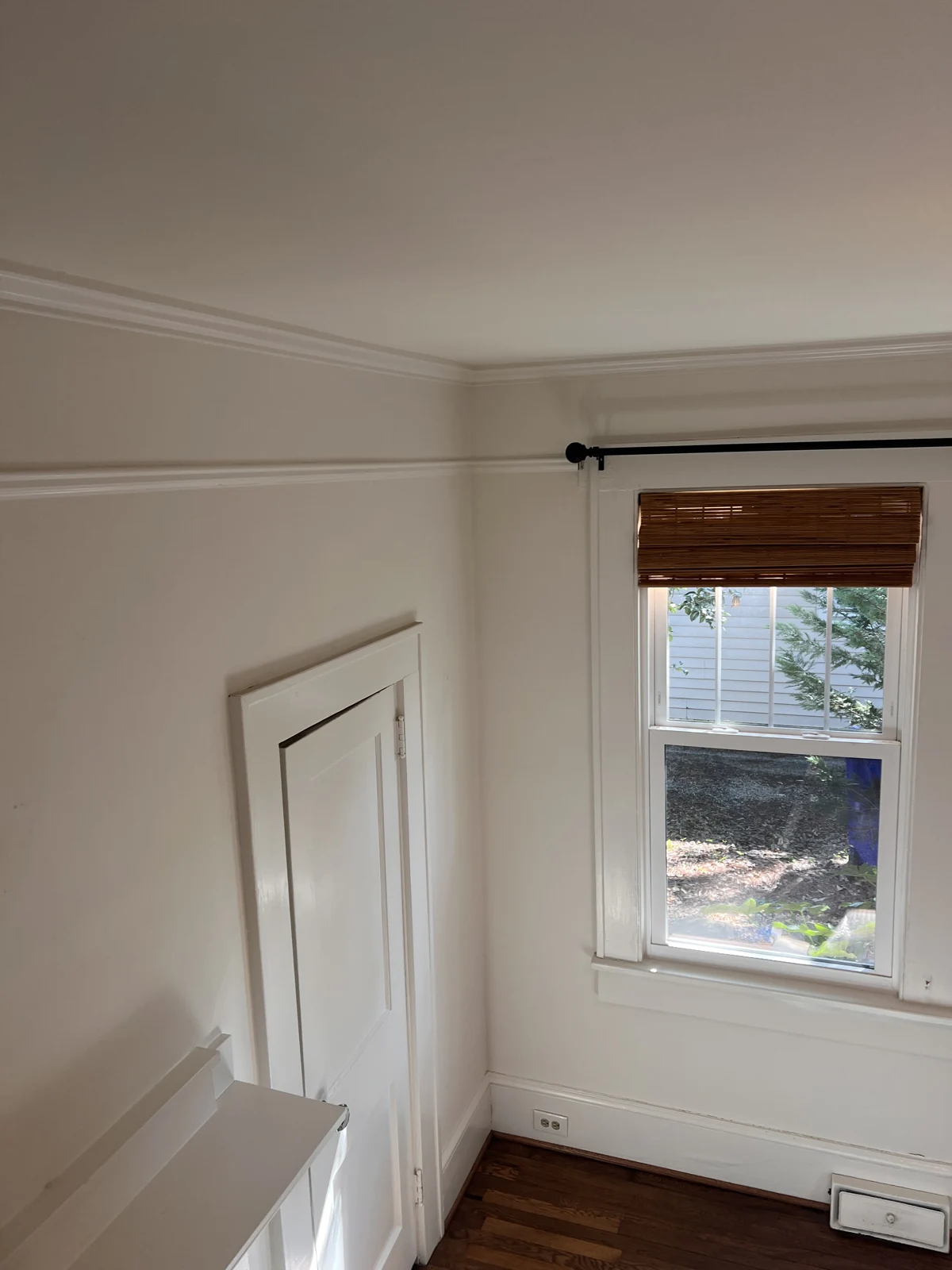 Cream walls beside a white door and window before painting