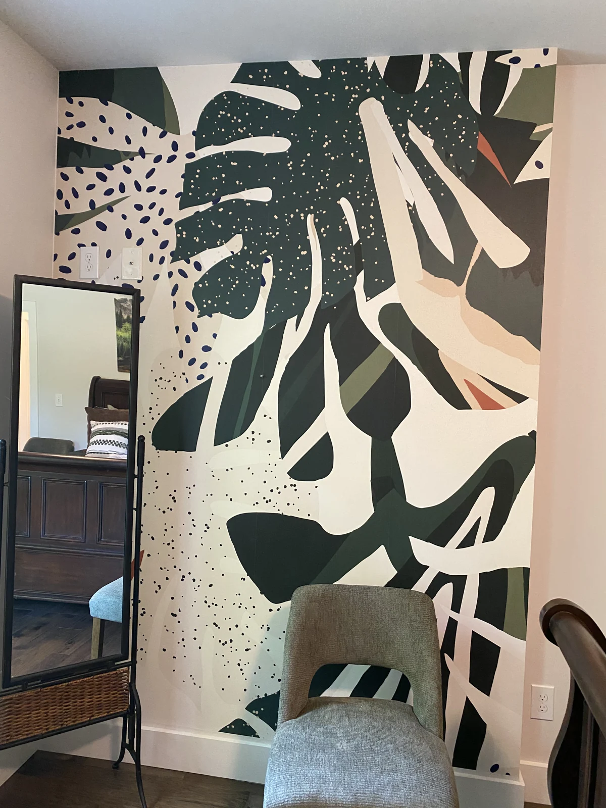 Close view of the installed botanical wallpaper beside a mirror
