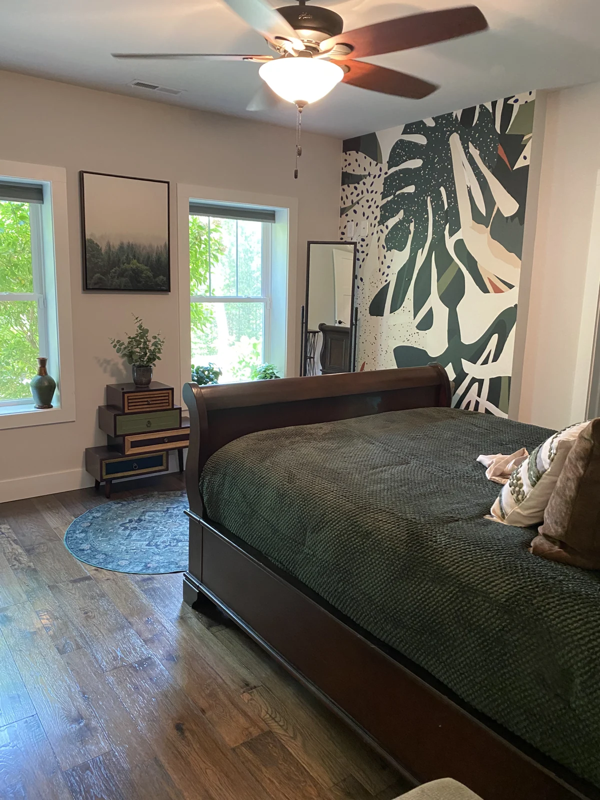 Bedroom with bold botanical wallpaper behind the bed