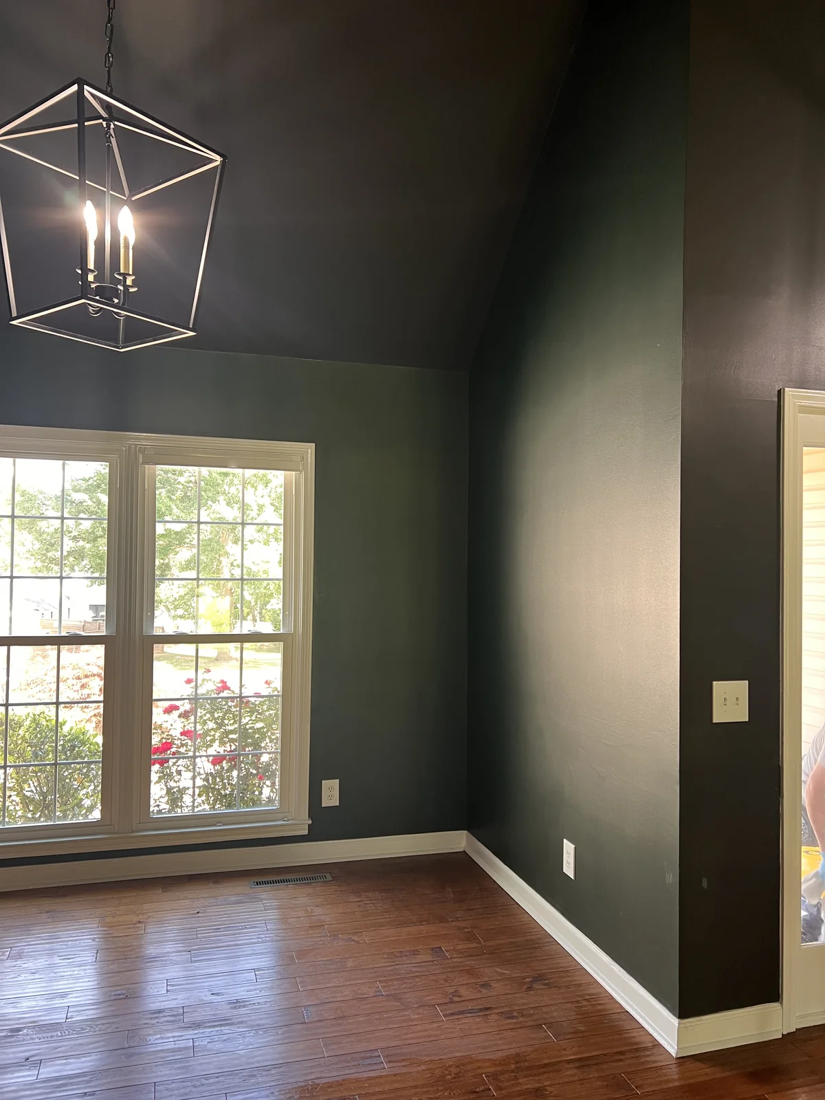 Dark charcoal painted walls around a tall window above a wood floor