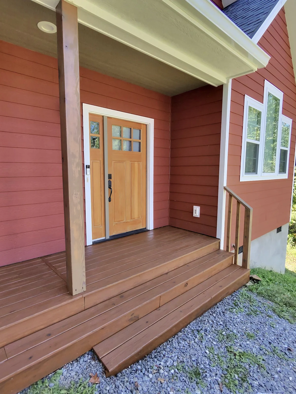 The same front deck and steps with a brown wood finish