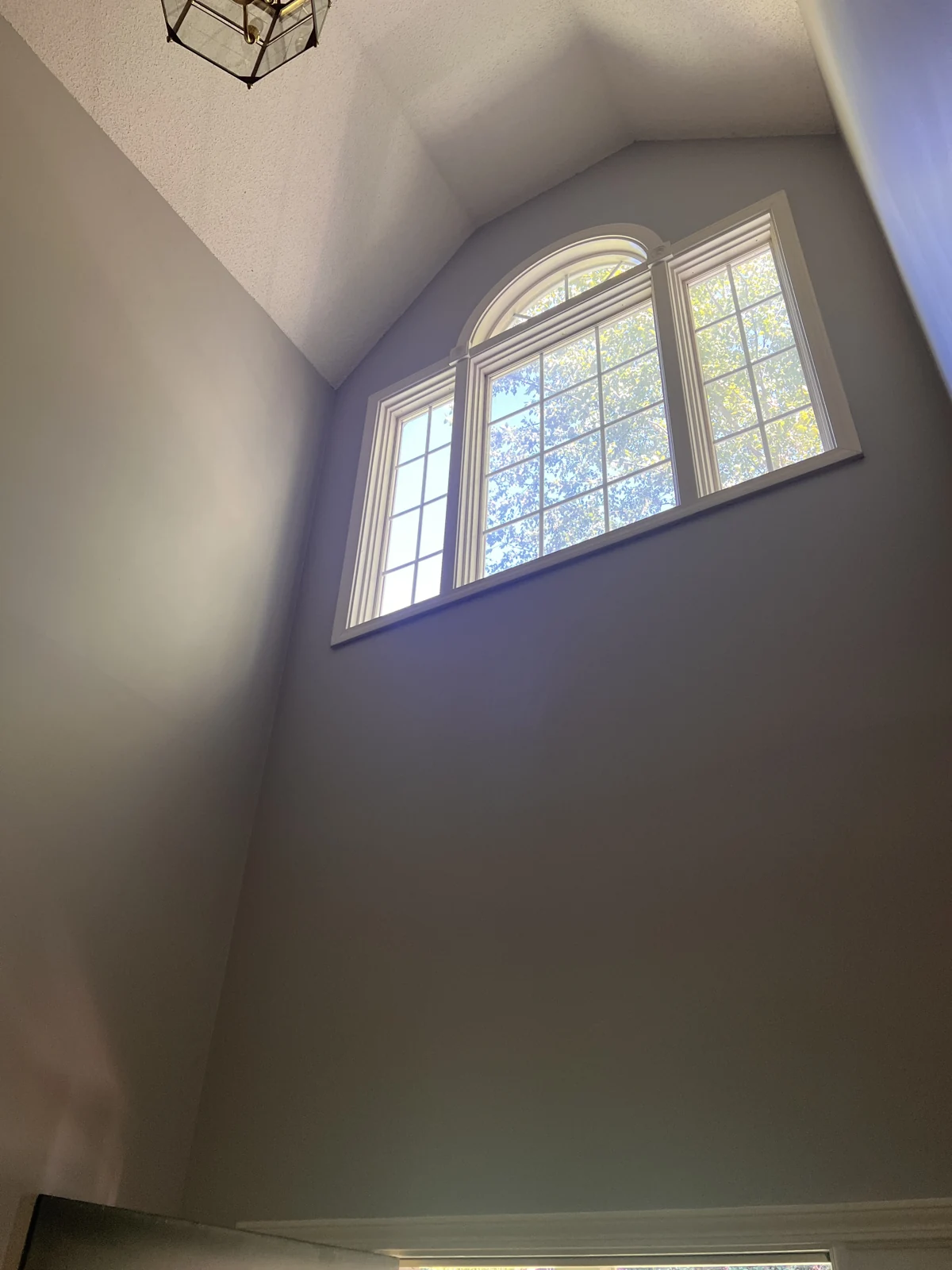 Painted entryway walls surrounding a high arched window