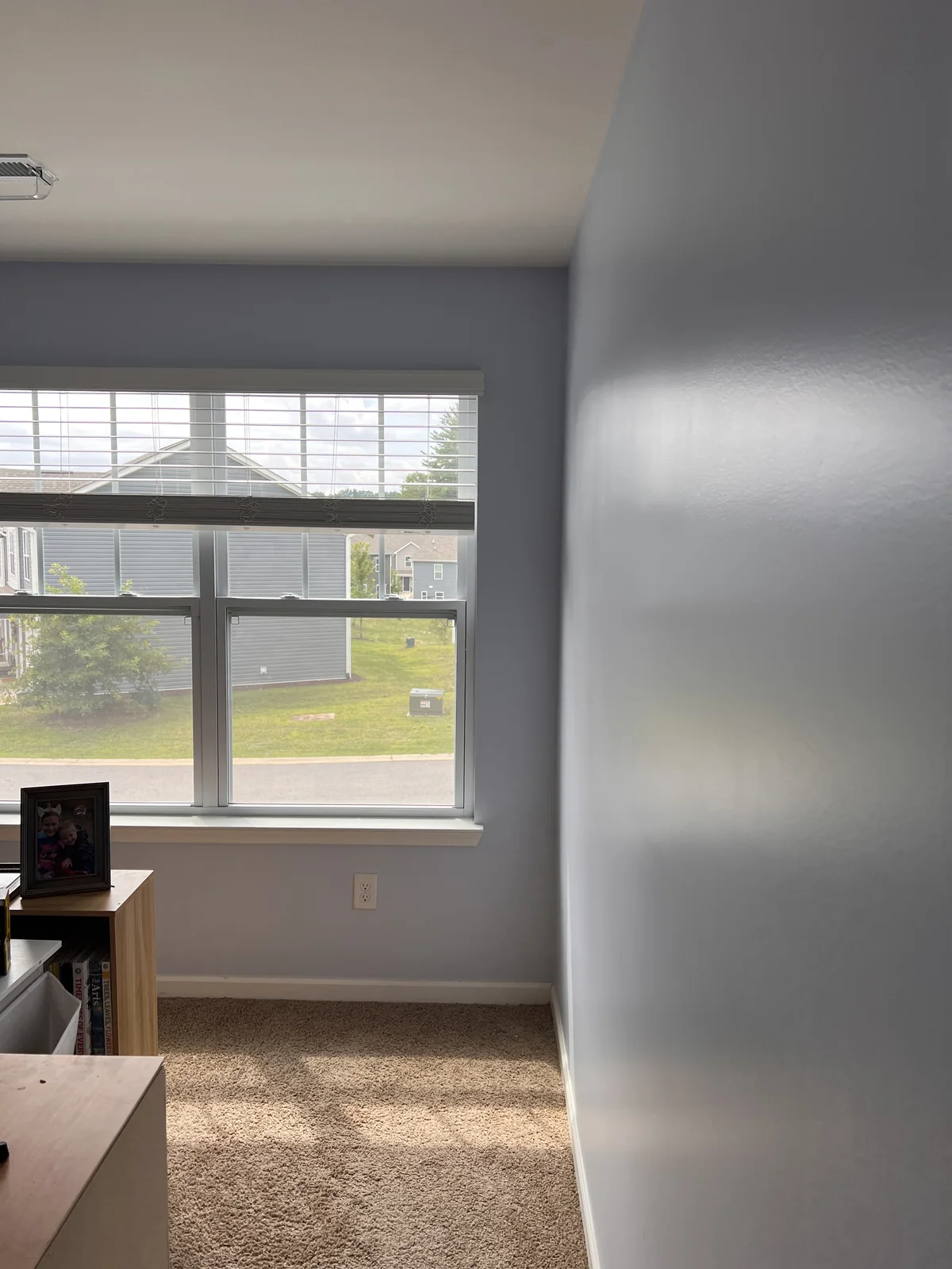 Pale blue room walls meeting a white-trimmed window