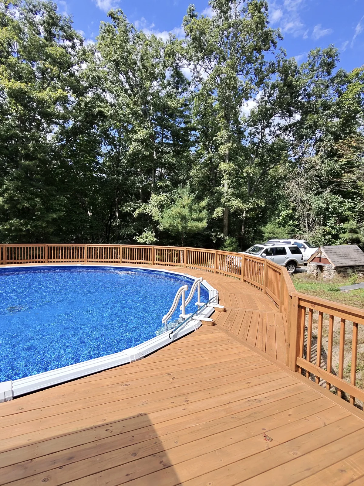 Brown-coated deck boards and railing beside an above-ground pool in Hendersonville